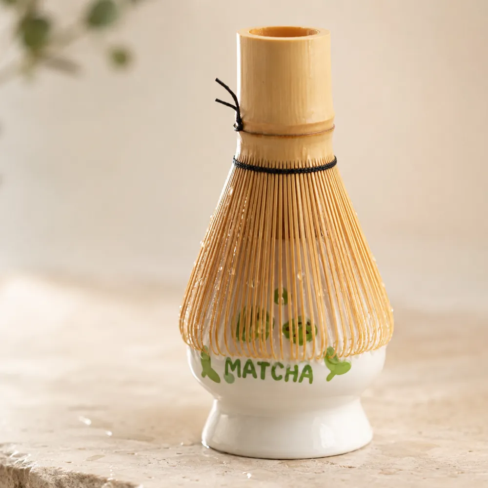Bamboo matcha whisk drying upright on the ceramic Kuji holder, keeping its tines in shape